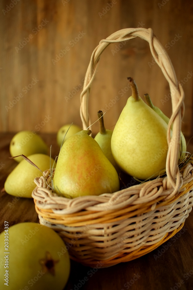 Little pears in a wicker basket on wooden background Little pears in a wicker basket on wooden background