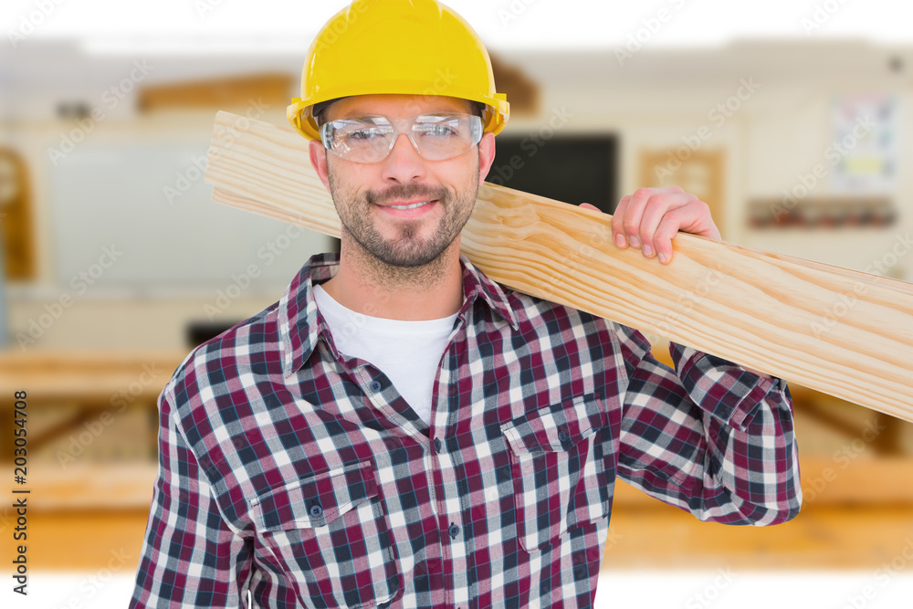 Handyman holding wood planks against workshop Handyman holding wood planks against workshop