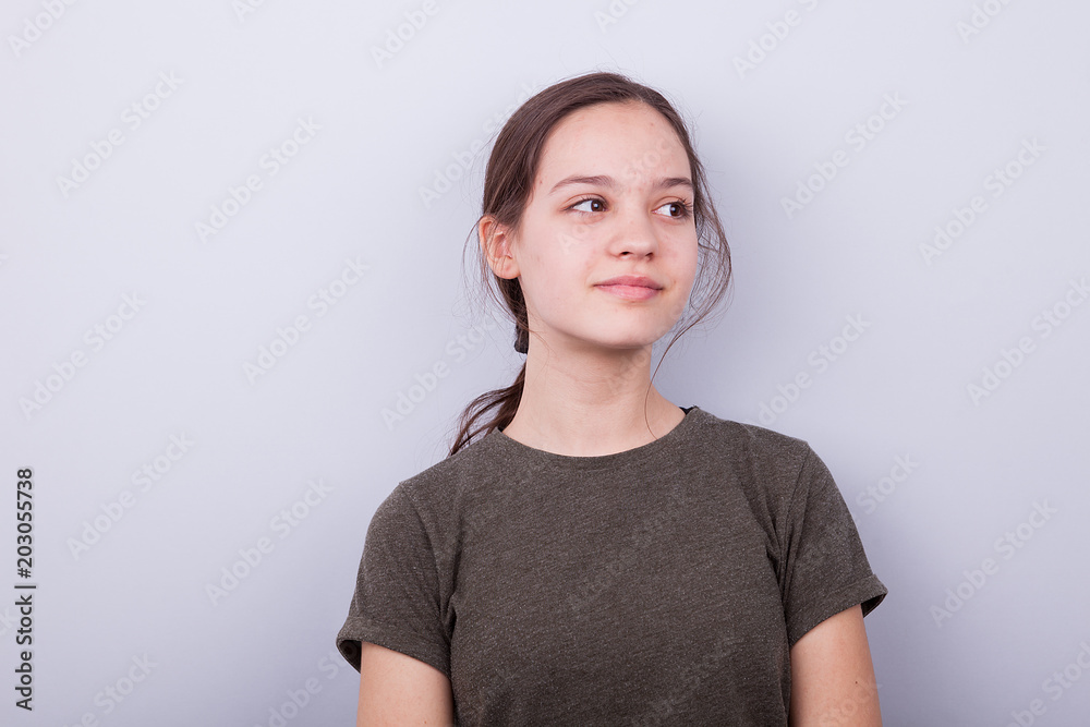 Portrait of cute teenage girl on gray background in studio Portrait of cute teenage girl on gray background in studio