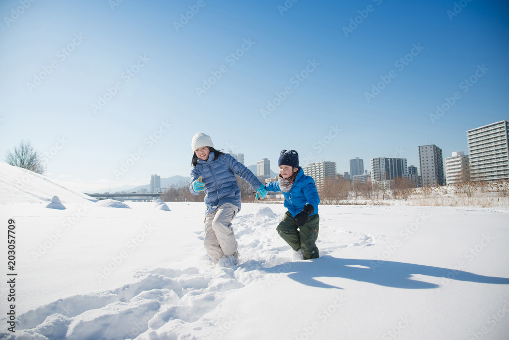 Cute Asian children playing on snow togethe