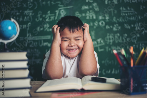  worried boy In classroom with hands on head