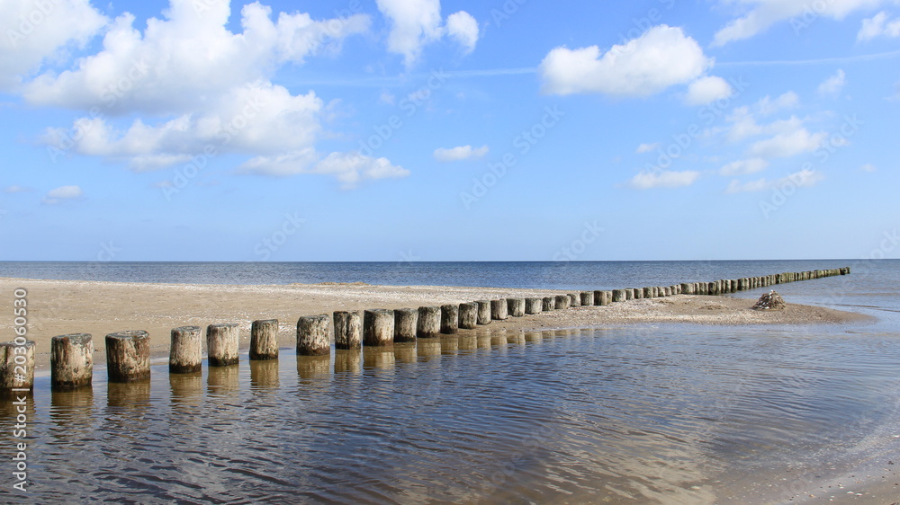 Baltic Sea During Springtime With wooden Groynes And Reflection