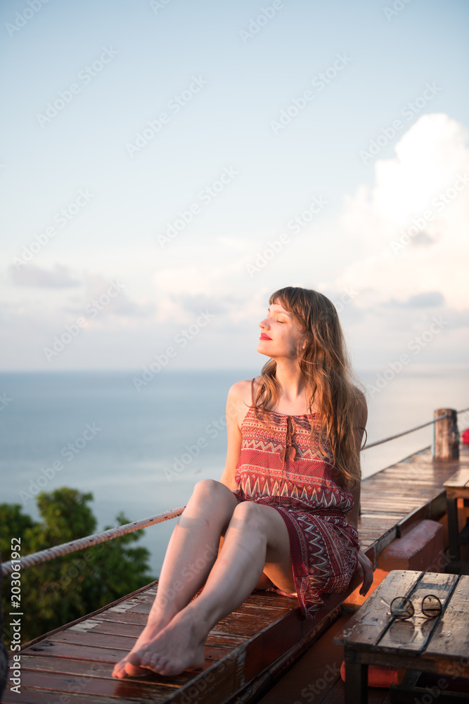 Woman on wood walk looking at ocean Woman on wood walk looking at ocean