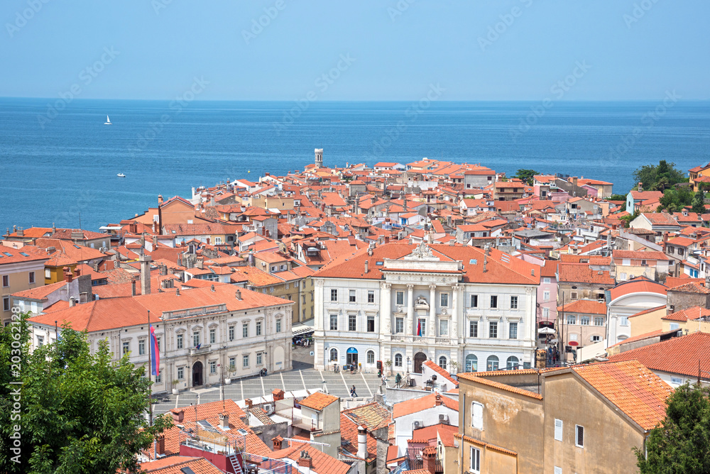 Beautiful scenery with tiled houses and roofs in the central square against the background of the blue sea in Porets, the tourist center of Croatia