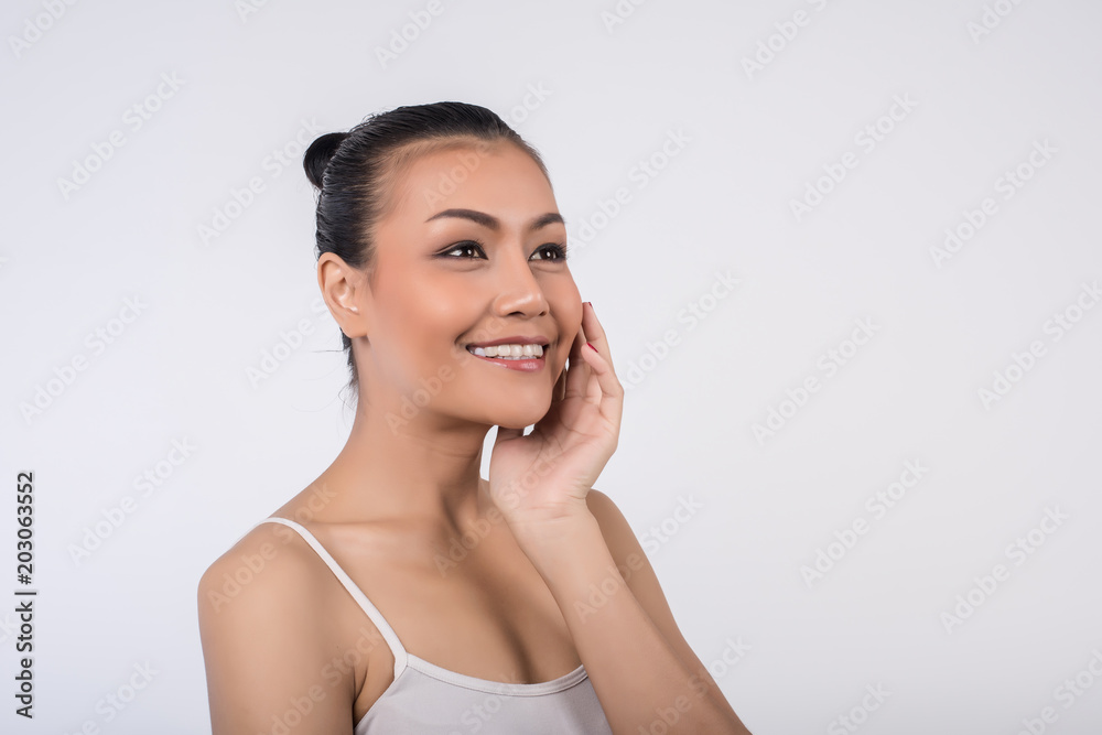 Beautiful Young Woman with Clean Fresh Skin touch own face