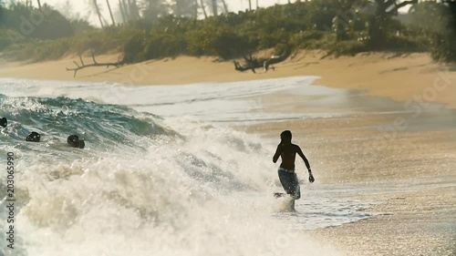 Snappy teenagers play in the stormy ocean waves in summer