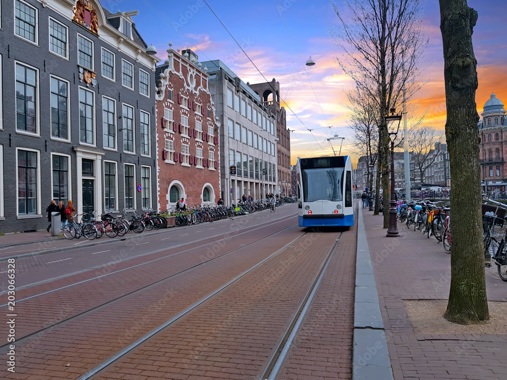 Obraz Tram driving in the city center from Amsterdam in the Netherlands at sunset