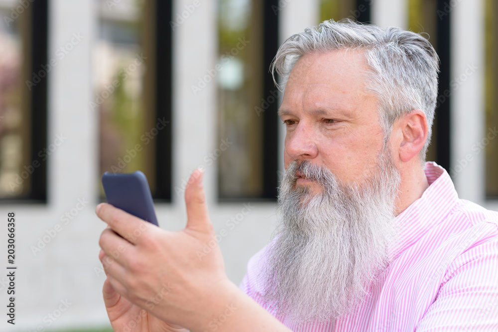 Attractive bearded man reading a text message