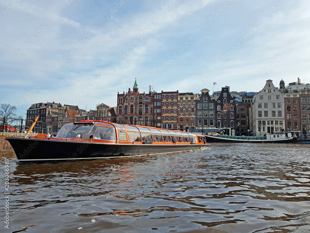 Fototapeta premium Cruising through Amsterdam canals in the Netherlands