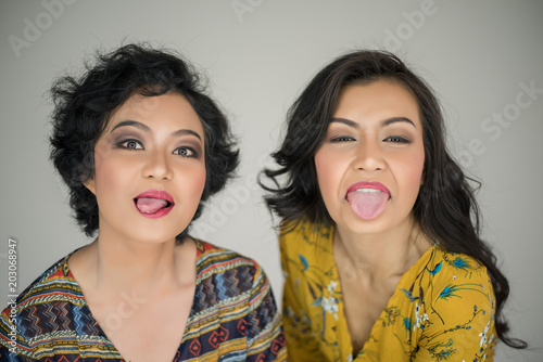 Funny young girl making faces on white background