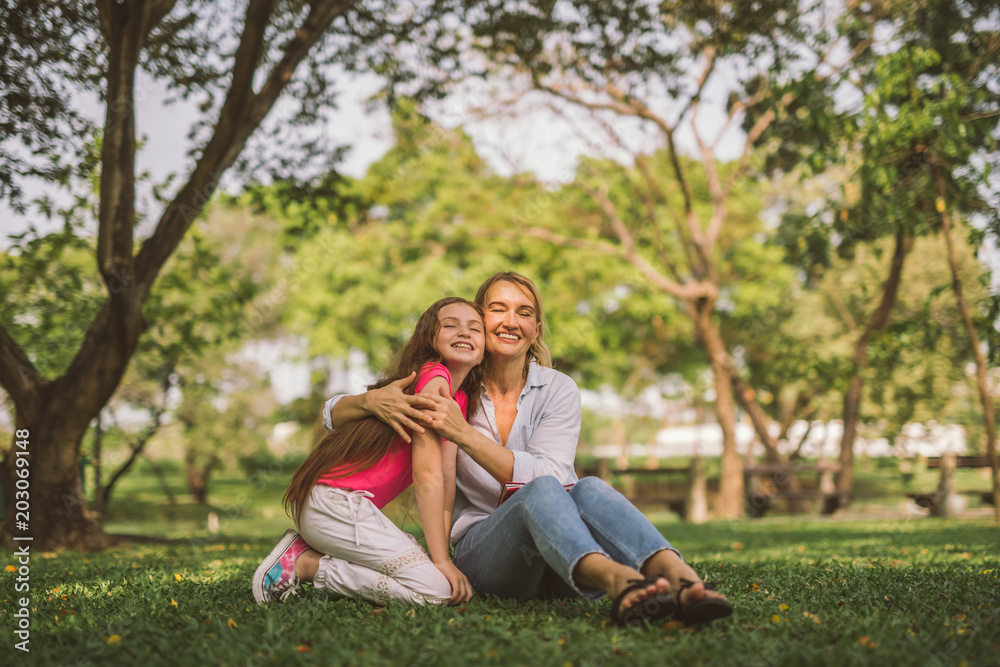 Portrait of Young Happy Beautiful Mother and Daughter Hugging. Embrace in Sunny Day on Meadow Portrait of Young Happy Beautiful Mother and Daughter Hugging. Embrace in Sunny Day on Meadow