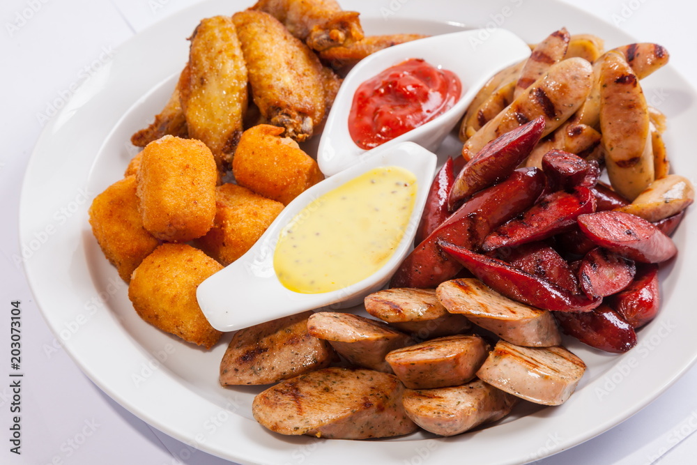 Grilled sausages on a plate with sauce