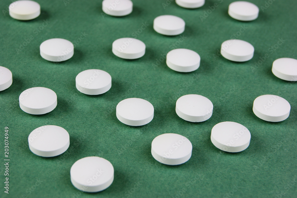 white tablets on a green background white tablets on a green background