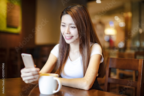 young woman using smart phone in coffee shop