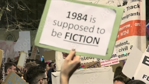 UK January 2017 - A hand holds up a protest placard that says, “1984 is supposed to be fiction”. photo