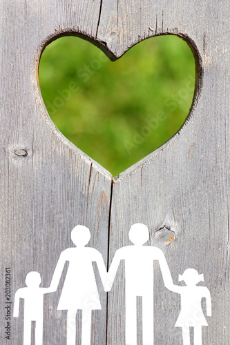 Family on wooden background with green heart welfare concept