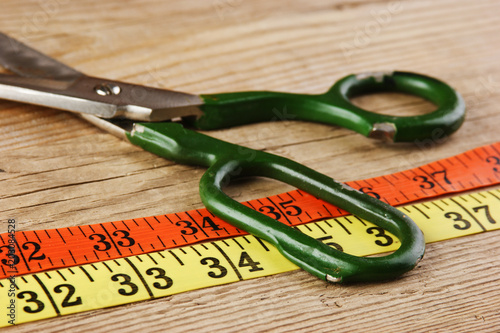 sartorial meter and scissors on the old wooden background