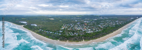 Wide aerial panorama of ocean coastline and Suffolk Park suburb in NSW, Australia