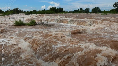 Southeast Asia’s largest Waterfalls, the Khone falls, at the end of the rainy season when it is most impressive as the Mekong River is swollen and caries large amounts of sediments turning it brown. 