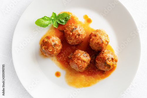 beef meatballs cooked with rice in tomato sauce decorated with basil