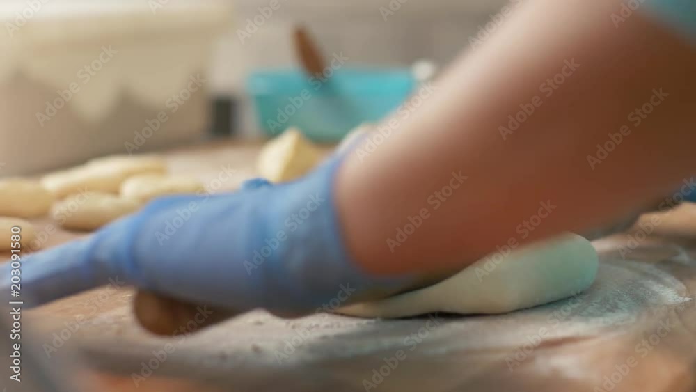 Baker rolling dough ball on table before baking pastries in bakerhouse close up Baker rolling dough ball on table before baking pastries in bakerhouse close up