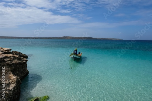 Tropical seascape with a boat anchored next to Cubagua island (Venezuela).