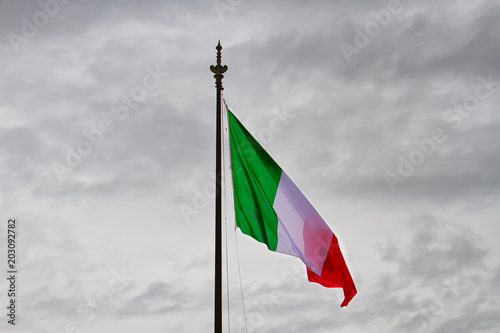 The flag of Italy in a genital breeze and cloudy sky.