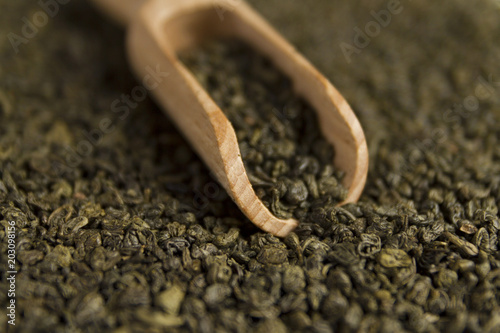 Photos Gunpowder green tea in scoop on tea background. Selective focus.