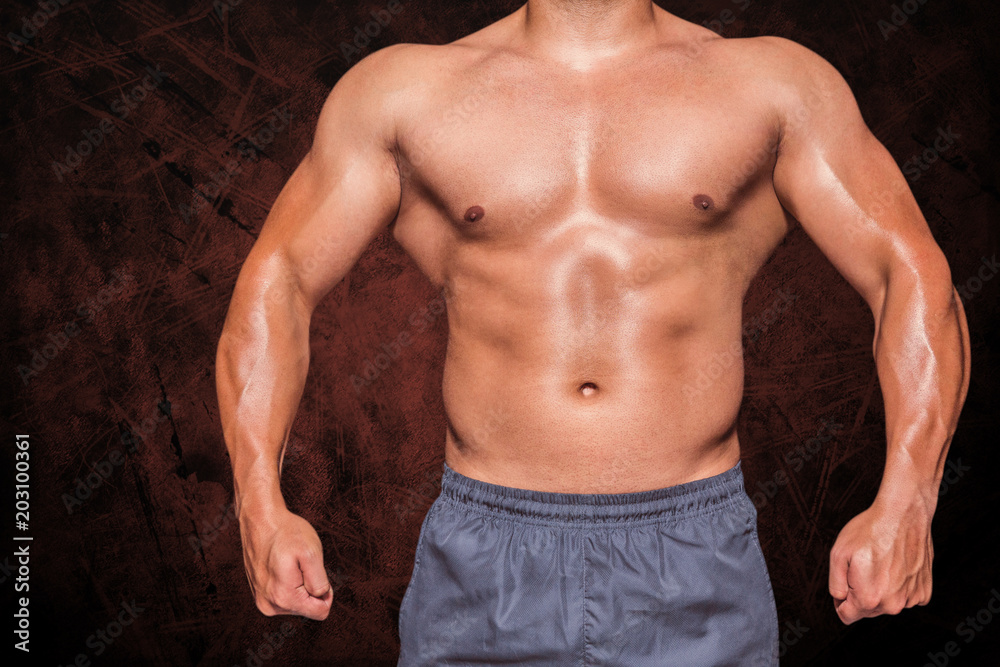 Obraz premium Mid section of a bodybuilder man against dark background