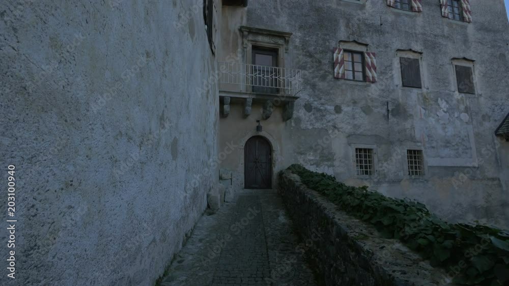 A stone alley leading to an arched door A stone alley leading to an arched door