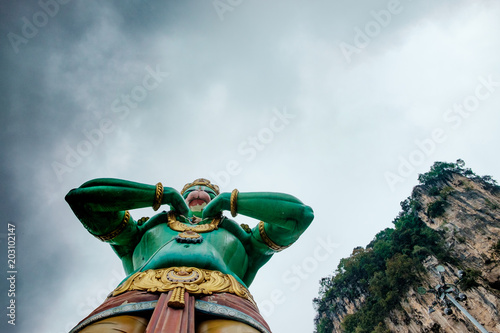 Photography huge blue statue of hindu god hanuman at entrance of batu caves during cloudy da
