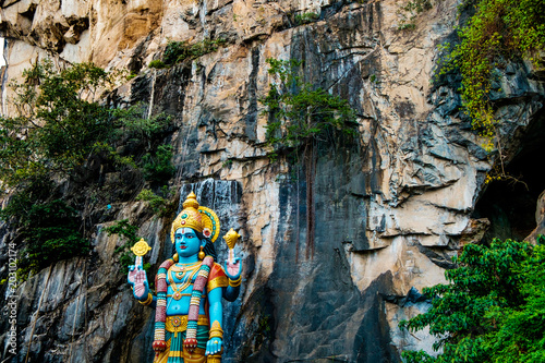 Photography huge blue statue of hindu god hanuman at entrance of batu caves during cloudy da