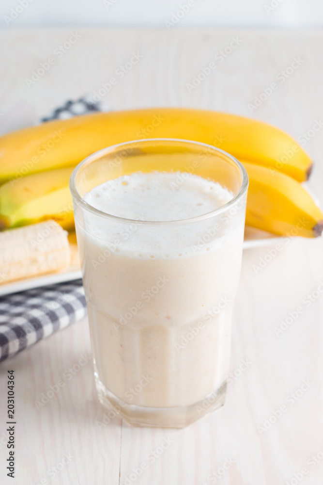 Fresh Made Chocolate Banana Smoothie on a wooden table. Selective focus. Milkshake with almonds. Protein diet. Healthy food and drink concept.