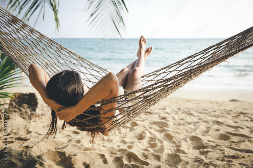 Happy woman relaxing in hammock - obrazy, fototapety, plakaty 