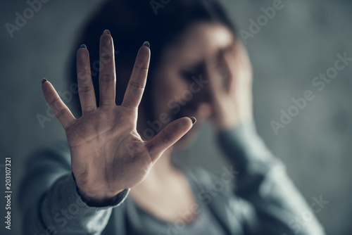 Oppressed woman shows by hand sign stop.