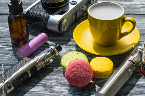 Still life with e-cig and jiuce on the wooden background photo
