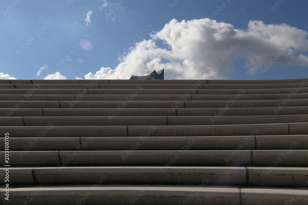 eine beton treppe und im hintergrund die elbphilharmonie in hamburg eine beton treppe und im hintergrund die elbphilharmonie in hamburg