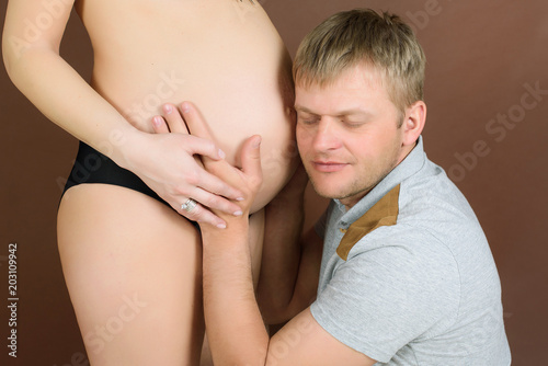 The husband and pregnant wife gently embrace the belly with unborn child. pregnant couple in love