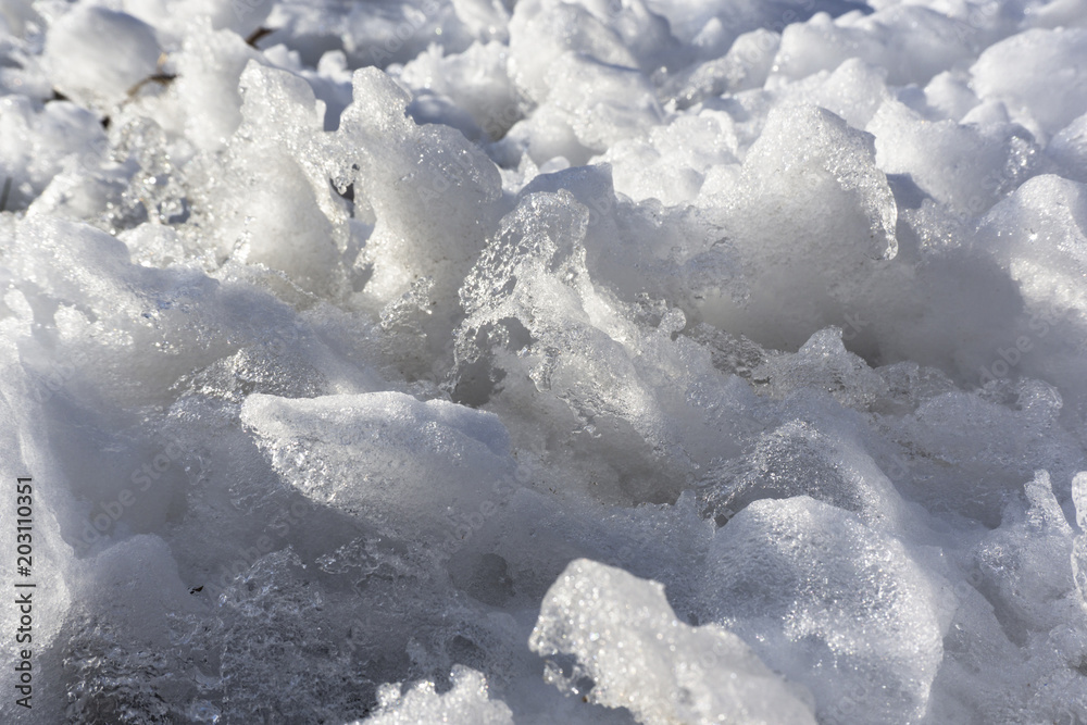 Close up detail of wave-like spikes of ice formed on melting snow..