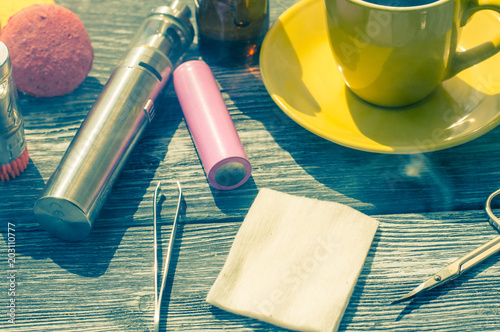 Still life with e-cig and jiuce on the wooden background photo