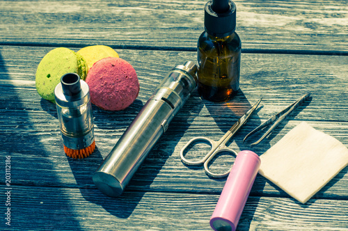 Still life with e-cig and jiuce on the wooden background photo