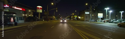 Rear view of a Driving Plate: Car travels on East Colorado Boulevard in Pasadena, California at night, crossing Craig Avenue, pausing near Sierra Madre Boulevard, and continuing on to make a left turn at Sunnyslope Avenue.