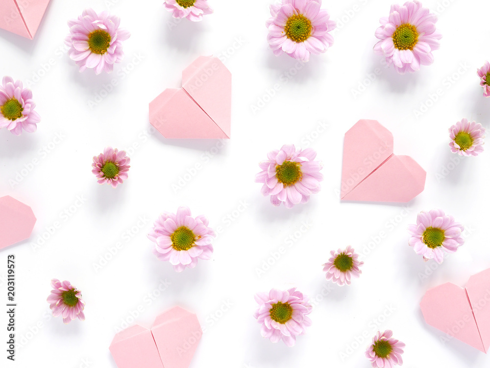 Composition of pink chrysanthemum flowers on and hearts made of paper, origami, top view, creative flat layout.