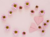 Composition of pink chrysanthemum flowers on and hearts made of paper, origami, top view, creative flat layout.