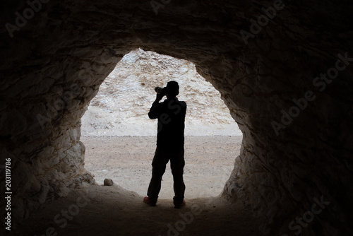 young photographer making photos in a cave