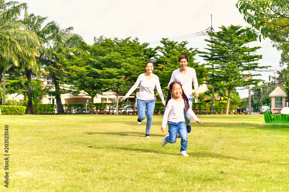 Obraz premium Parents and daughters go for a walk in the park.