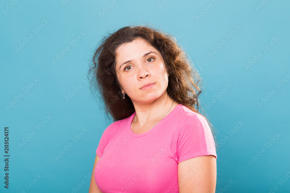 Close up portrait of a beautiful young woman with curly hair on blue background Close up portrait of a beautiful young woman with curly hair on blue background