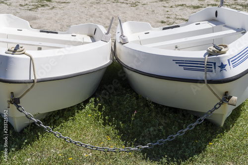 two boats tied with chain on the beach