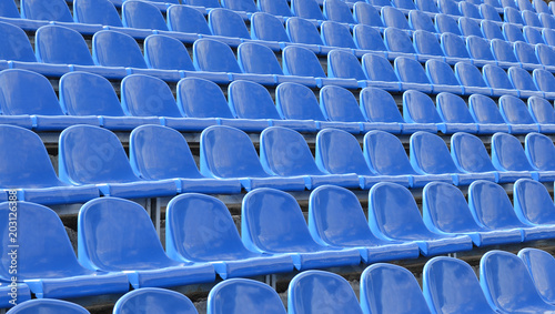 Rows of blue seats in the stands. Athletic facilities.