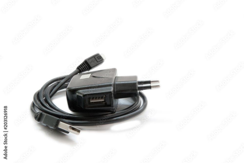 Black power adapter with USB cable for smartphones on a white background. Black power adapter with USB cable for smartphones on a white background.